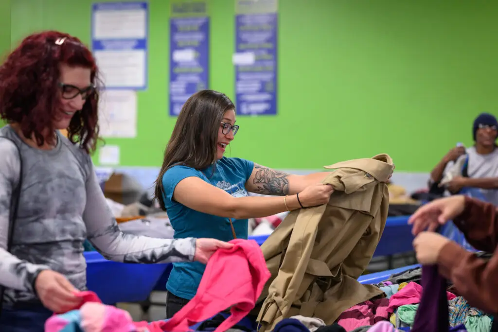Image of two women looking at clothes at a Goodwill outlet store