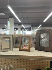 three picture frames in a shelf